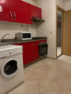 a kitchen with a washing machine and red cabinets at appartement 2 chabres marrakech in Marrakech