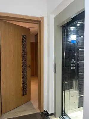 a glass door leading into a room with a walk in shower at appartement 2 chabres marrakech in Marrakech