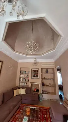 a living room with a couch and a chandelier at Appartement Ksour in Sraghna