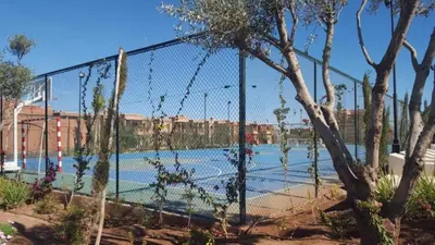 a chain link fence with a tennis court at Appartement Ksour in Sraghna