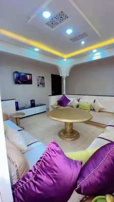 a room with purple and white pillows and a table at Apartment near Mènera gardens and city center in Marrakech