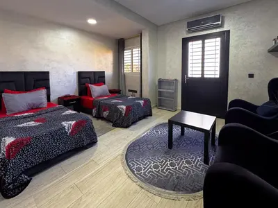 a room with two beds and a couch and a table at Apartment in Marrakech near McDonald's Massira in Marrakech