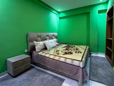 a green bedroom with a bed and a green wall at Apartment in Marrakech near McDonald's Massira in Marrakech