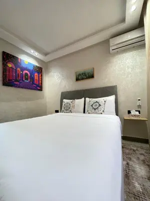 a bedroom with a large white bed in a room at MayyRakech in Marrakech