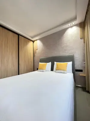 a bedroom with a large white bed with yellow pillows at MayyRakech in Marrakech