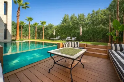 a swimming pool with a table and chairs on a deck at Palais Zahira in Marrakech