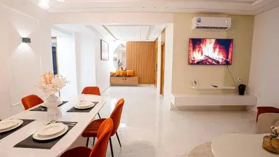 a dining room with a table and chairs and a fireplace at Appartement Moderne à Guéliz in Marrakech
