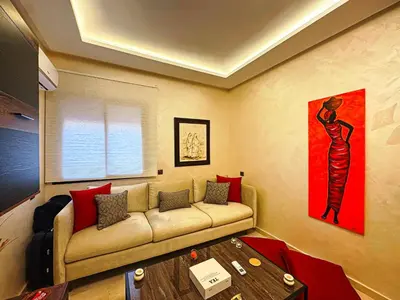a living room with a couch and a table at Le Nid de l'Hivernage - Piscine et Confort Moderne in Marrakech