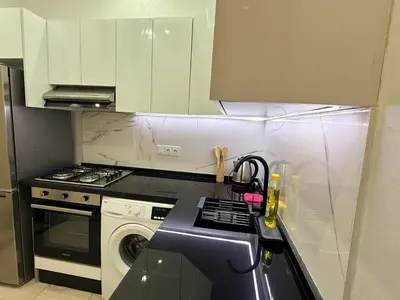 a kitchen with white cabinets and a washer and sink at Appartement Cosy and Calme Proche Centre Marrakech in Marrakech