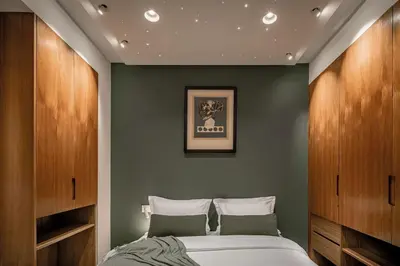 a bedroom with a bed with green walls and wooden cabinets at Luxury 3 bedroom with private pool and spa in Marrakech