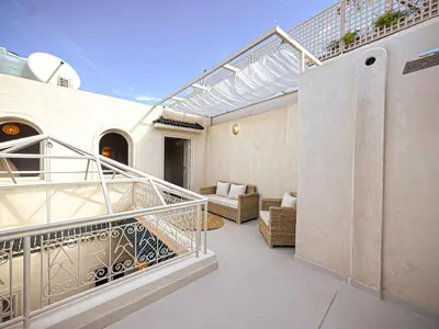 a balcony of a house with a staircase and a couch at Riad Medina Luxury Charm in Marrakech