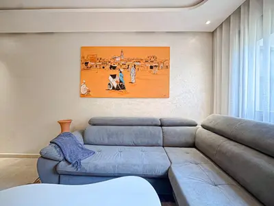 a living room with a couch and a painting on the wall at Le Pavillon Gueliz Appart Chic Confort et Piscine in Marrakech