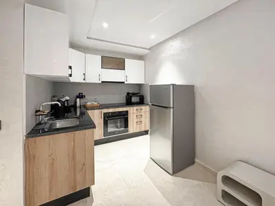 a kitchen with a sink and a refrigerator at Le Pavillon Gueliz Appart Chic Confort et Piscine in Marrakech