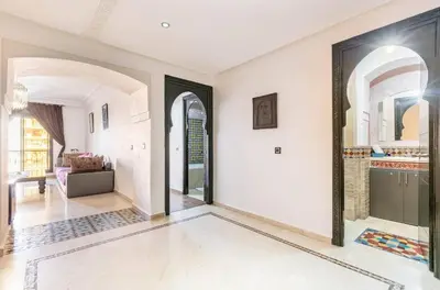 a living room with white walls and arched windows at Un super jolie appartement à gueliz in Marrakech