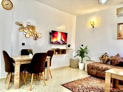 a living room with a table and a couch at Zyarat Marrakech in Marrakech