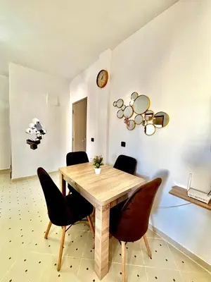 a dining room with a wooden table and chairs at Zyarat Marrakech in Marrakech