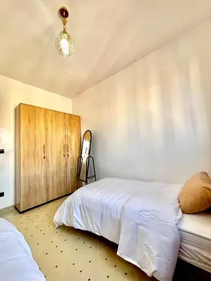 a bedroom with a bed and a wooden cabinet at Zyarat Marrakech in Marrakech