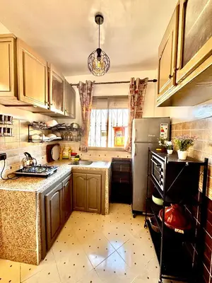 a kitchen with wooden cabinets and a refrigerator at Zyarat Marrakech in Marrakech