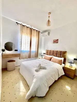 a bedroom with a large white bed and a window at Zyarat Marrakech in Marrakech