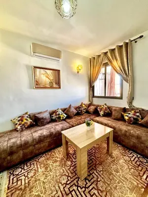 a living room with a brown couch and a table at Zyarat Marrakech in Marrakech