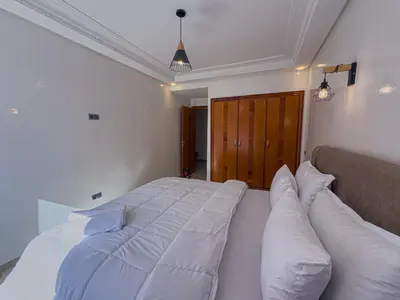 a bedroom with a large white bed with pillows at Essalmi Luxury Apartment Gueliz in Marrakech