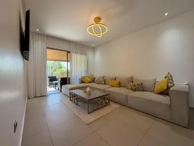 a living room with a couch and a table at Prestigia 3 Bedrooms witch pool and Garden in Marrakech