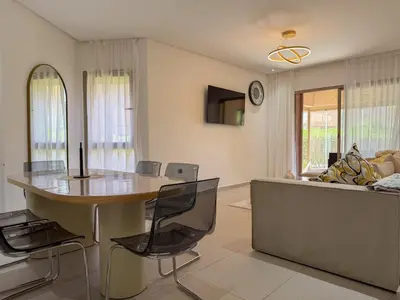 a living room with a table and a couch at Prestigia 3 Bedrooms witch pool and Garden in Marrakech