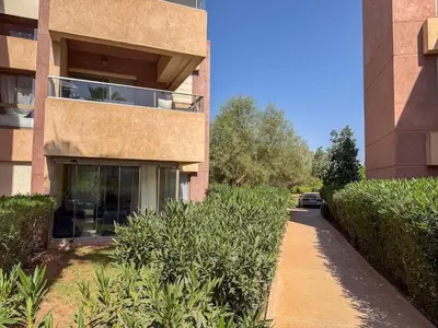a building with a car parked in front of it at Prestigia 3 Bedrooms witch pool and Garden in Marrakech