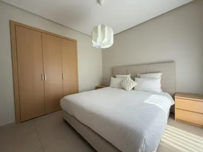 a bedroom with a large white bed and a chandelier at Prestigia 3 Bedrooms witch pool and Garden in Marrakech