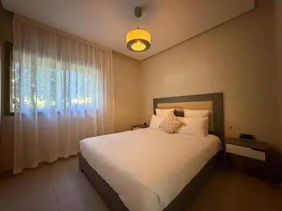 a bedroom with a large white bed with a window at Prestigia 3 Bedrooms witch pool and Garden in Marrakech