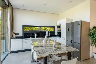 a kitchen with a marble table and a refrigerator at villa golfe in Marrakech