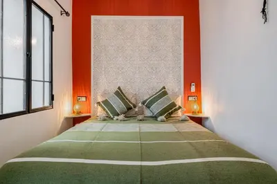 a bedroom with a large bed with orange walls at Riad with Rooftop Terrace in Top Medina Location, Dar El Bacha in Marrakech