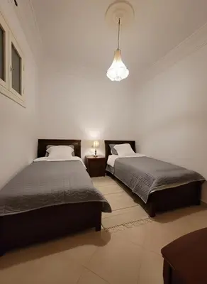 a bedroom with two beds and a light fixture at Dar'ESTRELLA calme 15min Jemaa ElFna parking free in Marrakech