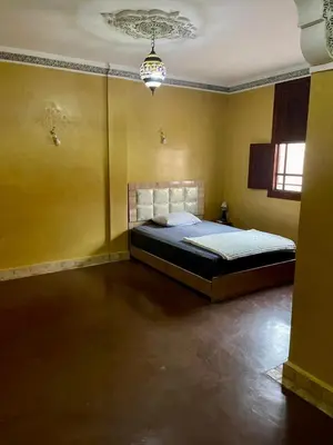 a bedroom with a bed in a yellow room at Séjours villa riad pour familles in Marrakech