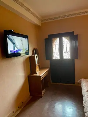 a room with a tv and a door and a window at Séjours villa riad pour familles in Marrakech