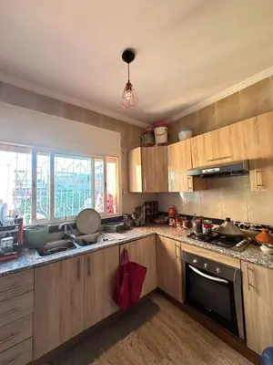 a kitchen with wooden cabinets and a counter top at Bouchouk Apparts Gueliz in Marrakech