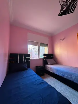 two beds in a room with pink walls at Bouchouk Apparts Gueliz in Marrakech