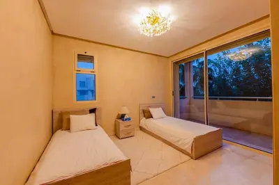 two beds in a room with a large window at Villa Sophia in Marrakech