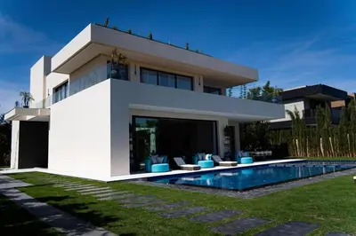a white house with a swimming pool in front of it at Villa California in Marrakech