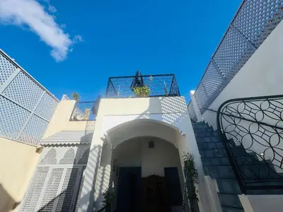 a white house with a gate and a staircase at Riad Blue Berry in Marrakech