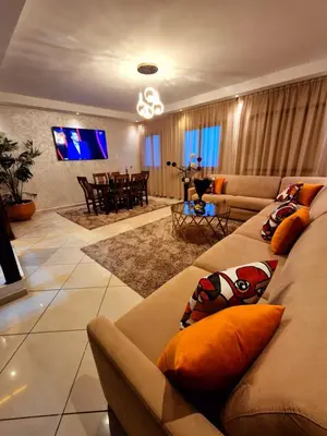 a living room with a couch and a tv at Duplex familiale au centee du Marrakech in Marrakech