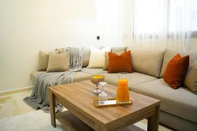 a living room with a couch and a coffee table at Appartement Moderne & Cosy Proche Centre Piscine, Wi-Fi Haut Débit & Netflix Marrakech in Marrakech