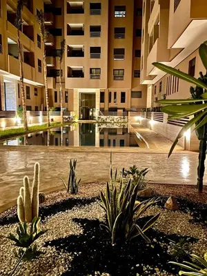 a building with a courtyard with plants and a pool at Appartement Moderne & Cosy Proche Centre Piscine, Wi-Fi Haut Débit & Netflix Marrakech in Marrakech