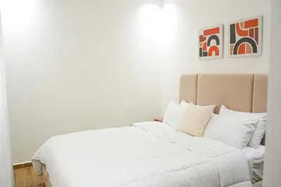 a bedroom with a white bed with white pillows at Appartement Moderne & Cosy Proche Centre Piscine, Wi-Fi Haut Débit & Netflix Marrakech in Marrakech