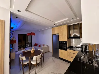 a kitchen and living room with a table and chairs at Aube d hivernage Marrakech in Marrakech