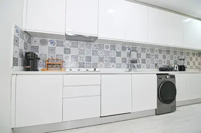 a kitchen with white cabinets and a washing machine at Downtown Prestige 2Br apartment cinema AC in Marrakech