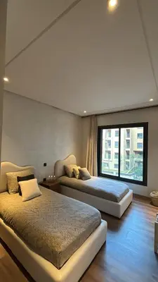 two beds in a bedroom with a large window at Luxurious 2 Bedrooms in Gueliz Pool View in Marrakech
