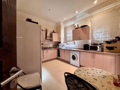 a kitchen with a table and a white refrigerator at Marrakech Luxury Escape Full Villa Pool & Garden in Sraghna