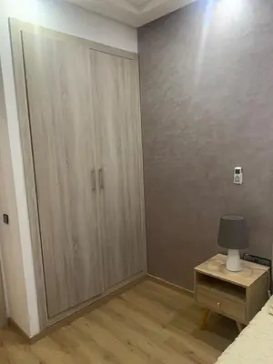 a bedroom with a large closet and a table with a lamp at 2 Bedroom Apartment Calm Area Parking in Marrakech