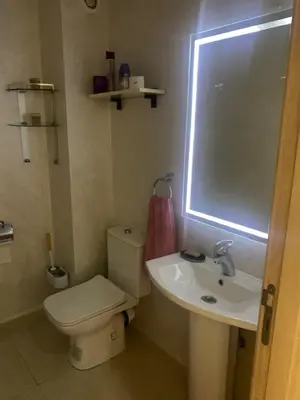 a bathroom with a toilet and a sink and a window at 2 Bedroom Apartment Calm Area Parking in Marrakech